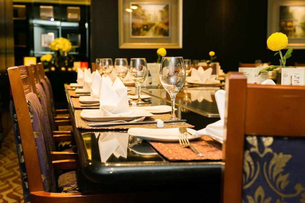 Evergreen Laurel Hotel - Тайджун Екстериор снимка The photo depicts a dining table set for a formal meal. The table is long, covered with a dark tablecloth, and has neatly arranged plates, forks, and glasses at each setting. White napkins are folded elegantly, and there are small yellow flowers as c