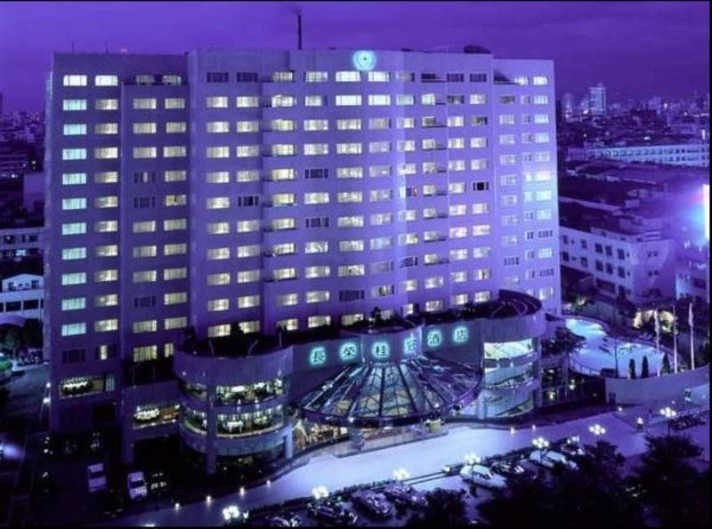 Evergreen Laurel Hotel - Тайджун Екстериор снимка The photo shows a large hotel building illuminated in a purple hue during the evening or nighttime. The facade features numerous windows, many of which are lit, suggesting occupancy. The entrance area appears modern and curved, with a design that inc