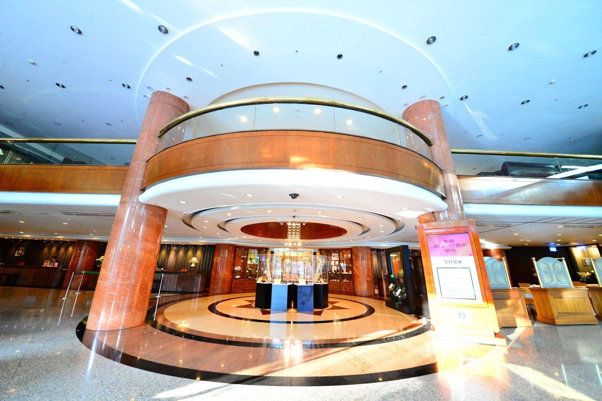 Evergreen Laurel Hotel - Тайджун Екстериор снимка The photo shows the interior of a spacious lobby area. It features a modern architectural design with polished surfaces and a circular ceiling structure. The walls are accented with wooden panels, and there is a central chandelier hanging from the ce