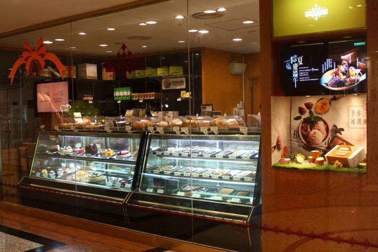 Evergreen Laurel Hotel - Тайджун Екстериор снимка The photo shows a display case in a bakery or dessert shop. The glass case is filled with a variety of pastries, cakes, and desserts arranged neatly. Behind the display, there is a counter with additional items and desserts visible. The walls are dec