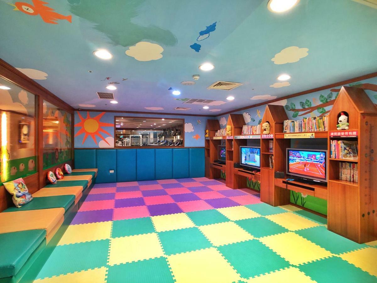 Evergreen Laurel Hotel - Тайджун Екстериор снимка The photo shows a brightly colored children's playroom or activity area. The floor is covered with large colorful tiles in shades of blue, green, yellow, and pink, creating a playful pattern. The walls have cheerful decorations, including sun and clo