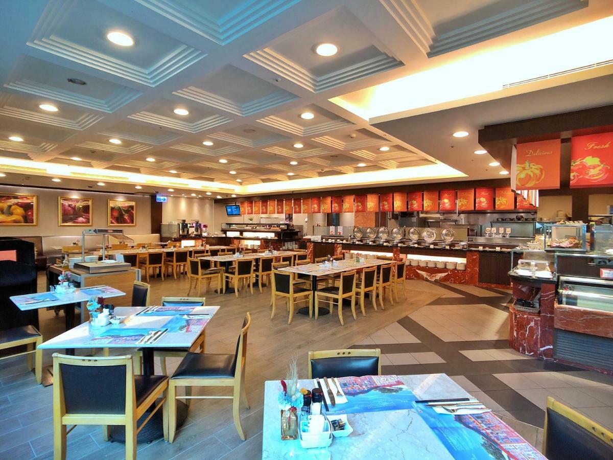 Evergreen Laurel Hotel - Тайджун Екстериор снимка The photo shows the interior of a restaurant. The dining area features several tables with chairs arranged neatly. The flooring has a contemporary design, and the ceiling is structured with a coffered pattern. There is a buffet area along one wall wi