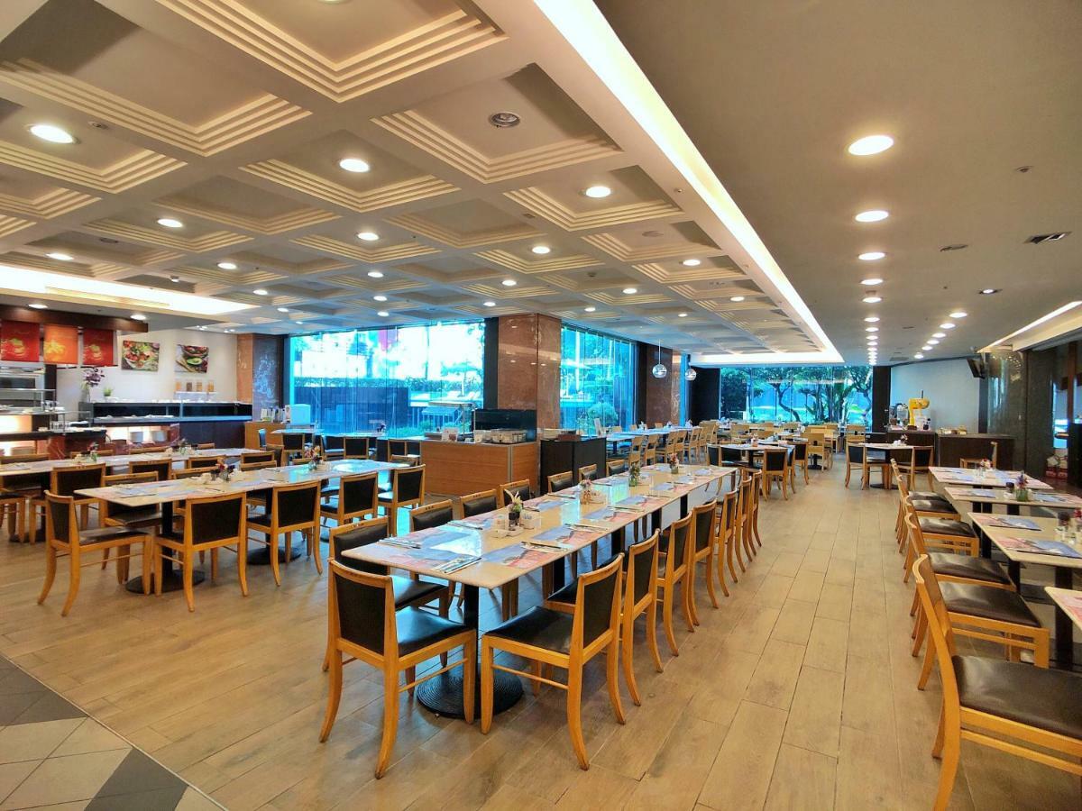 Evergreen Laurel Hotel - Тайджун Екстериор снимка The photo shows the interior of a restaurant. It features a spacious dining area with several wooden tables and chairs arranged in rows. The floor has a light wood finish, complementing the stylish design. The ceiling is decorated with a modern patte