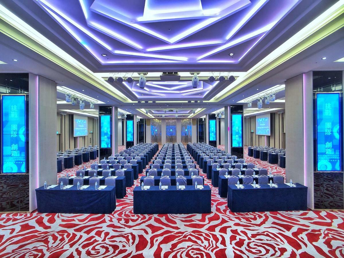 Evergreen Laurel Hotel - Тайджун Екстериор снимка The photo shows a large conference or seminar room set up for an event. The space features rows of tables and chairs arranged neatly, likely for attendees to participate in discussions or presentations. The room is well-lit with modern, colorful ligh