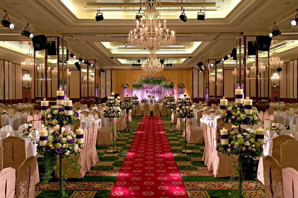 Evergreen Laurel Hotel - Тайджун Екстериор снимка The photo shows an elegantly decorated banquet hall set up for a wedding or formal event. The center aisle is lined with rows of elegantly draped chairs and features a bright red carpet. On either side of the aisle, there are beautifully arranged flo